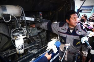 Un funcionario muestra el motor de uno de los Wayna Buses.